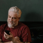 Пожилой человек использует мобильные приложения на смартфоне