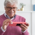 Пожилые люди за компьютером играют в цифровые игры