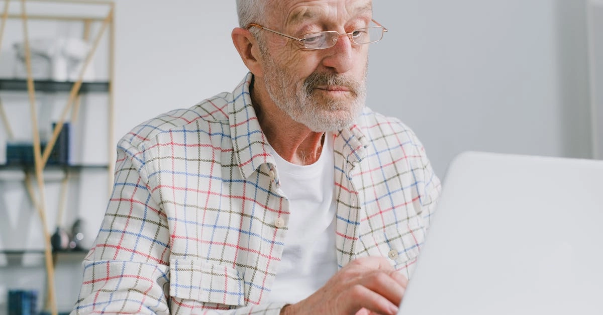 Пожилой человек за компьютером играет в цифровые игры